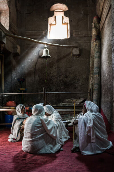 Four women sitting on the floor of a church during Orthodox Easter celebrations, Lalibela, Ethiopia, Africa